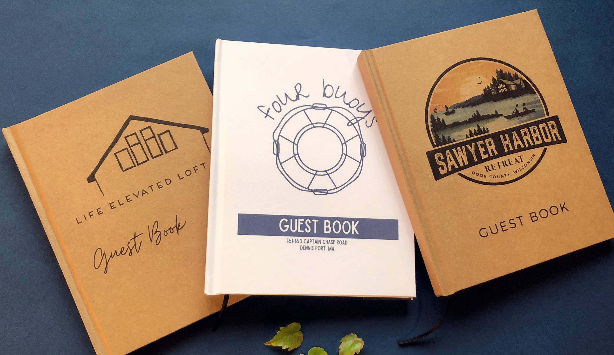 Three personalized vacation home guest books with different logos on a blue background. Hardback covers, hand crafted. Heirloom quality.